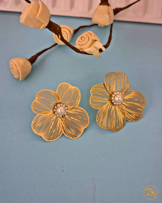 Gold flower-shaped earrings with a central pearl on a blue background