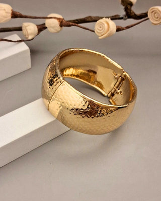 Gold bracelet on a neutral background with decorative elements