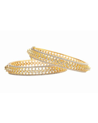 Gold bangles with intricate designs on a white background