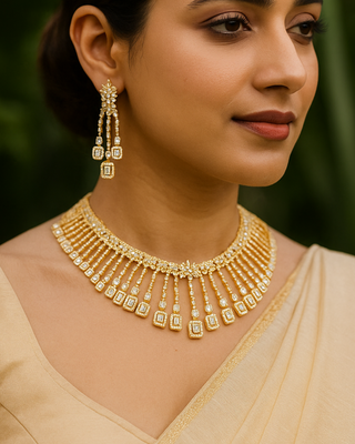 Woman wearing a gold necklace and earrings with a blurred green background
