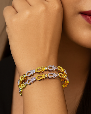 Woman wearing a gold bracelet with a neutral background