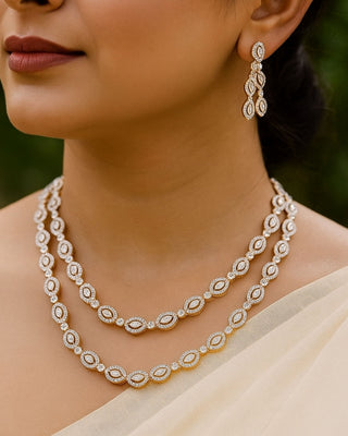 Close-up of a woman wearing a diamond necklace and earrings with a blurred background