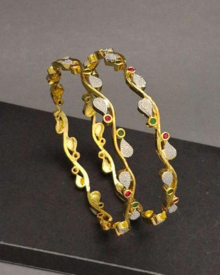 Gold hoop earrings with gemstones on a black surface