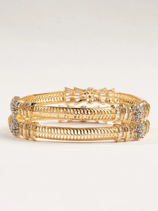 Gold bracelet with intricate design on a light gray background