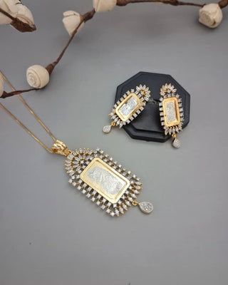 Gold necklace and earrings on a gray surface with decorative elements.