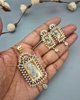 Gold and diamond-encrusted jewelry set on a hand with a neutral background
