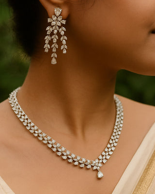 Diamond necklace and earrings on a model with a blurred green background